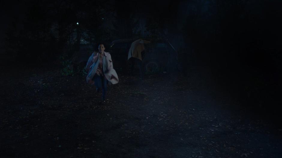 Macy runs away from the abandoned car where the demon is frozen.