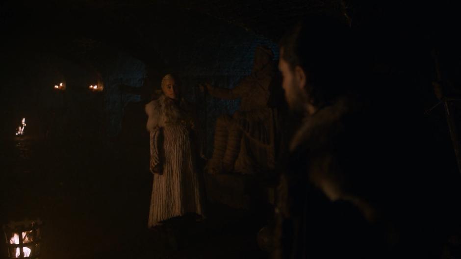 Jon turns and looks at Dany as she asks who is depicted in the statue.