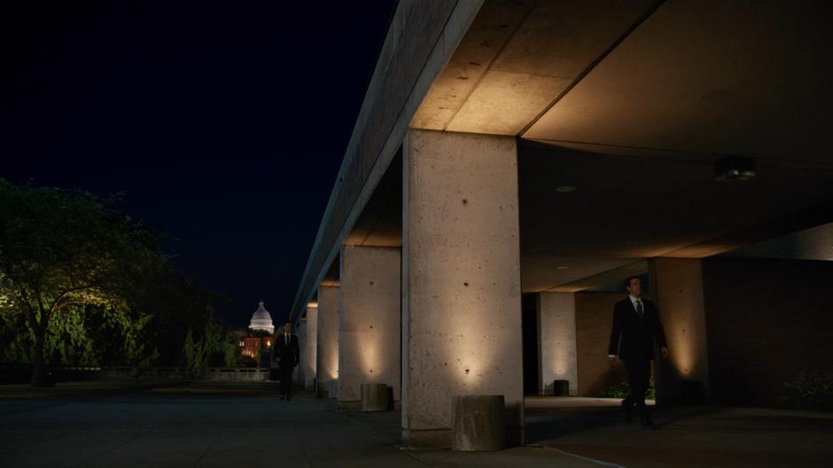 Time Bureau agents walk around outside the agency with the Capitol Building in the background.