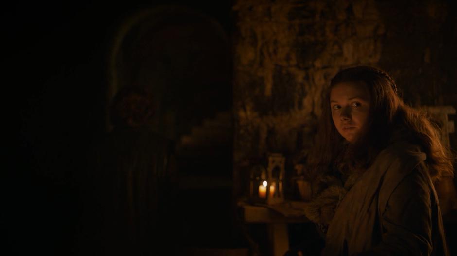 Gilly looks over at the others in the crypt while Tyrion watches the entrance stairs.