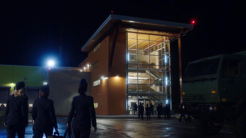 Brie Larvan, Nora, and Joss Mardon approach the entrance to the building where others are entering.