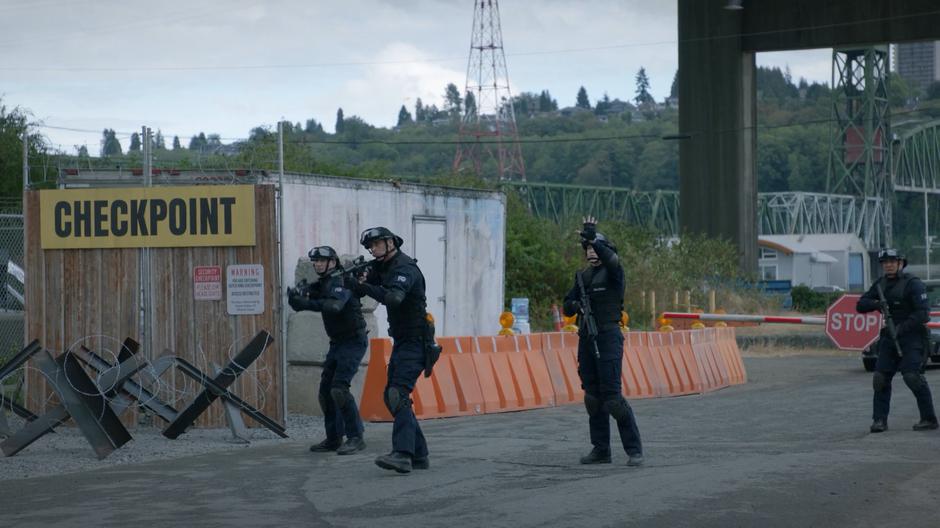 The guards at the checkpoint motion for the van to stop.