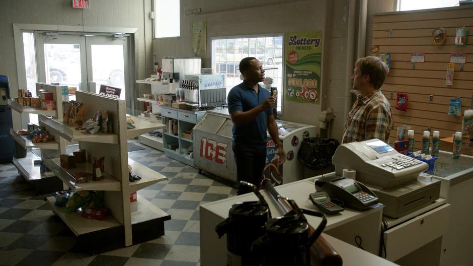 Clive shows the cashier his badge and asks to see the security footage.