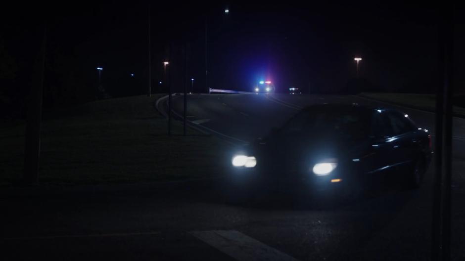 Tyrone turns the stolen car off the main road as the police crest a hill behind them.