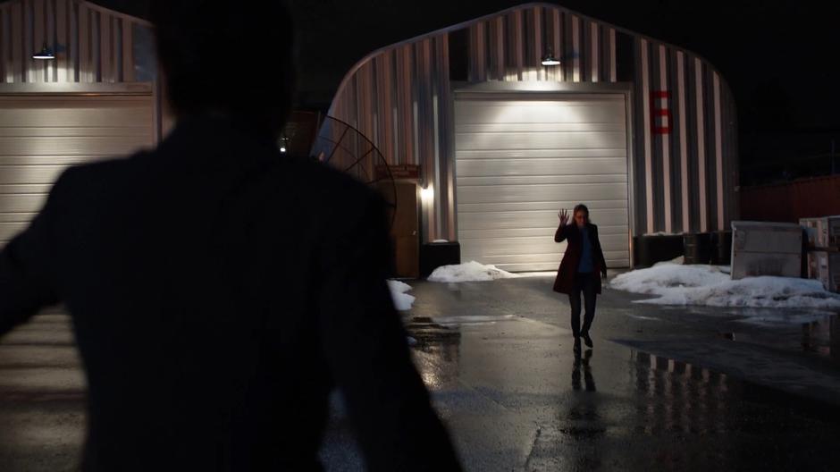 Lena runs towards Kara who waves at her after escaping the explosion.