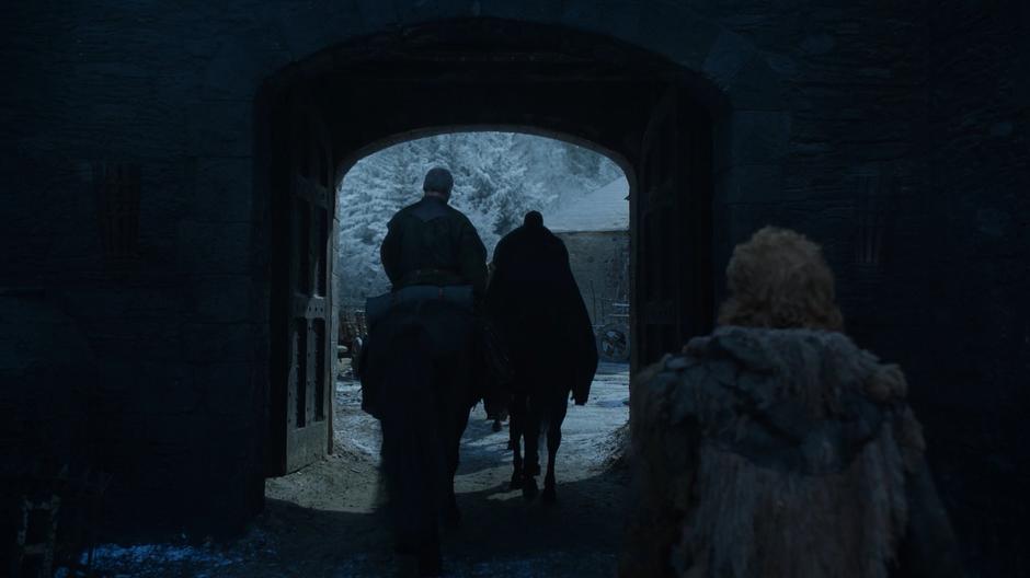 Tormund Giantsbane watches as Davos and Jon ride out through the castle gates.