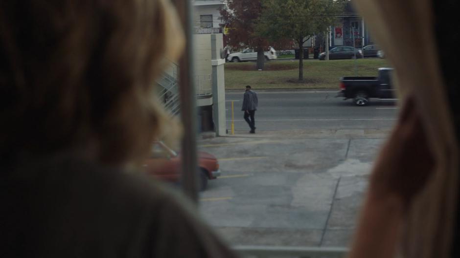 Tandy watches the guard patroling in front of the motel from her window.