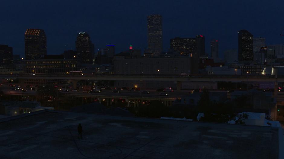 Tyrone finishes drawing the giant vèvè on the rooftop overlooking downtown.