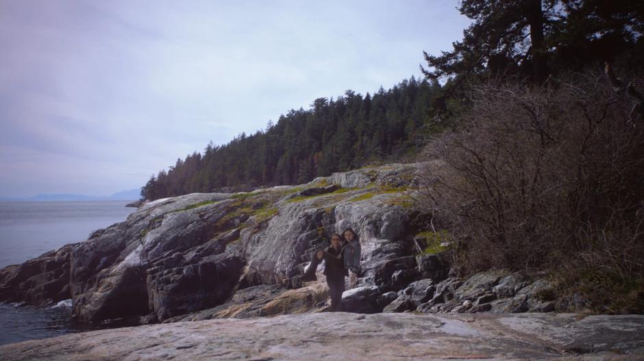 Young Kara flies into the air with Alex in her arms after they both fell off the cliff.