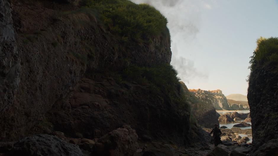 Jaime walks along the shore to the secret cave entrance.