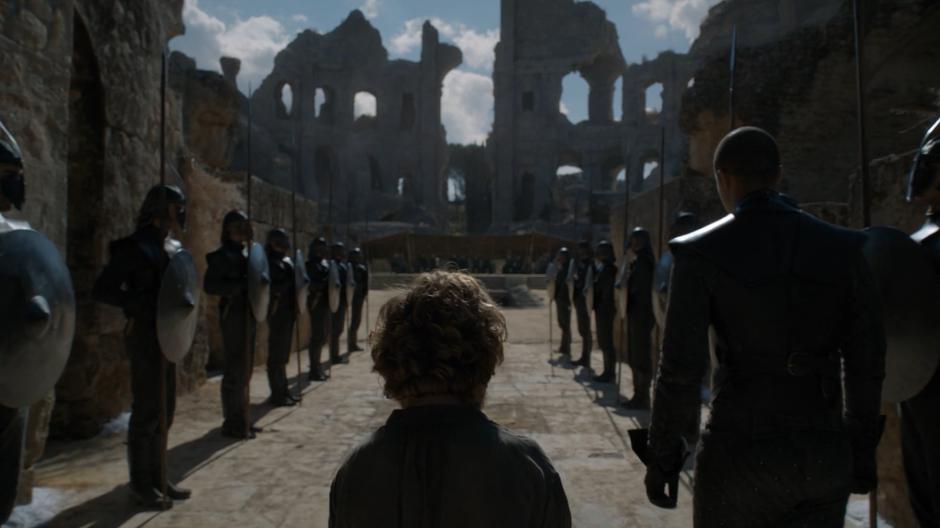 Tyrion follows Grey Worm past a line of Unsullied into the Dragonpit.