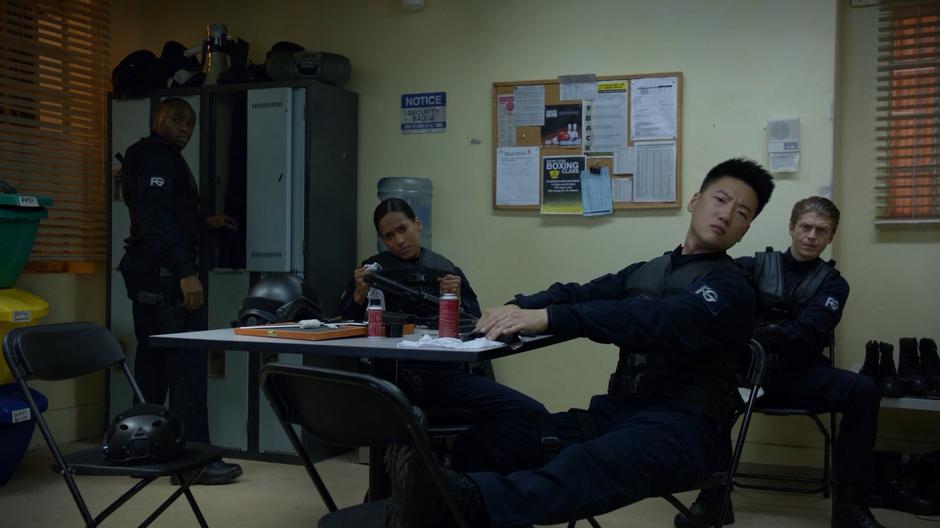 Four Fillmore Graves mercenaries who were cleaning their equipment in the break room look to the door as it opens.