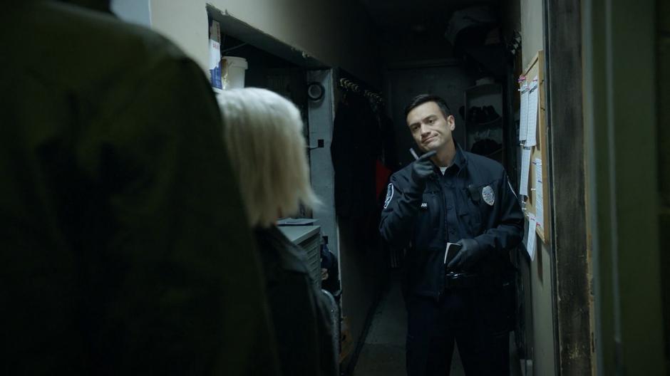 A police officer points Liv and Ravi towards the office where the body was found.