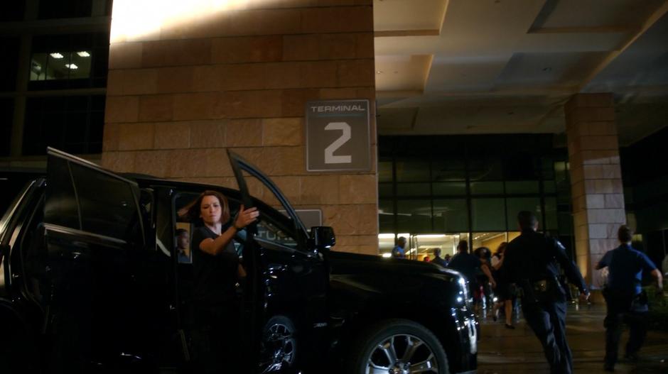 Alex climbs out of her SUV as police rush to evacuate the building.