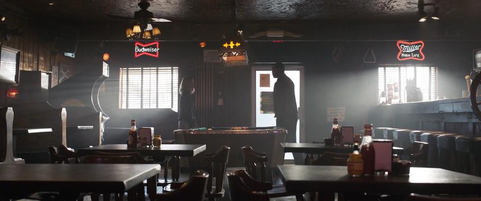 Fury approaches Carol at the front of the bar and asks how he can prove his identity.