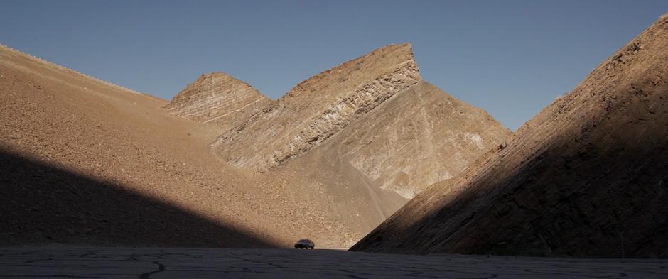 Fury drives his car across the road through some cliffs towards the base entrance.