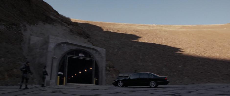 Several guards watch as Fury drives into the tunnel leading to the base.