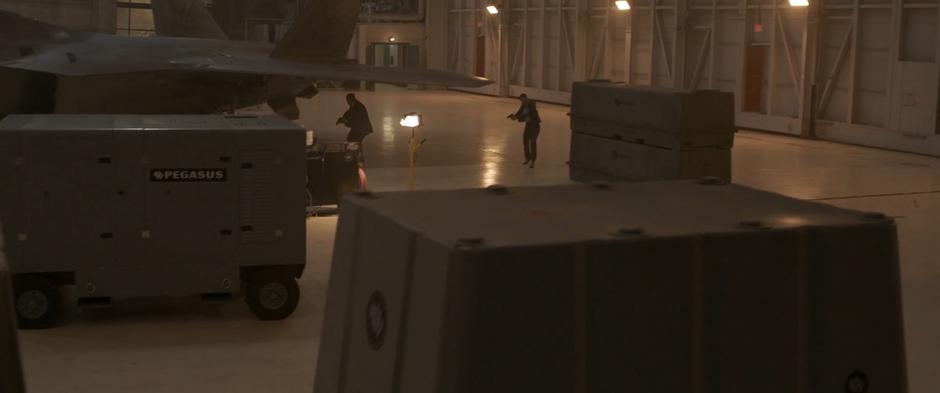 S.H.I.E.L.D. agents search the hanger for Vers and Fury.