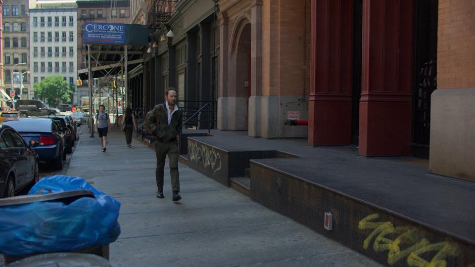 Andrew Brandt walks down the sidewalk after leaving his apartment.