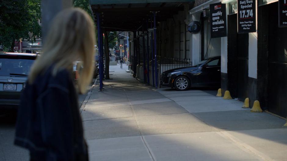 Trish looks down the street to where Jessica is crossing the street.