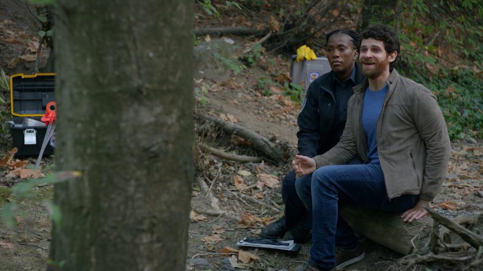 Lisa's boyfriend looks up from where he was crying with a police officer and smiles at her.