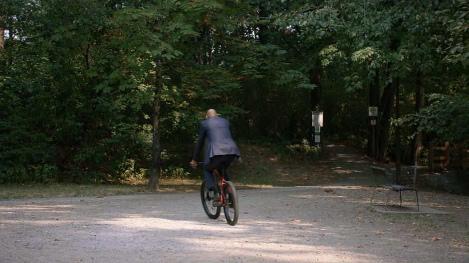 Zed rides off down the trail on his bike.