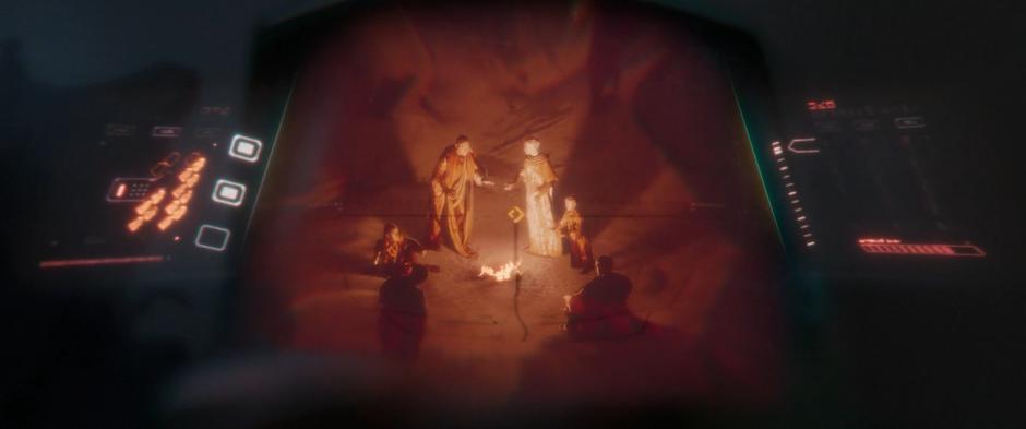 Several locals are visible standing around a fire in Minn-Erva's scope.