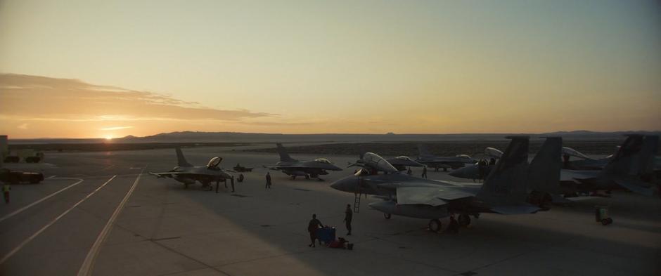 Pilots and ground crew prepare the jets at sunrise.