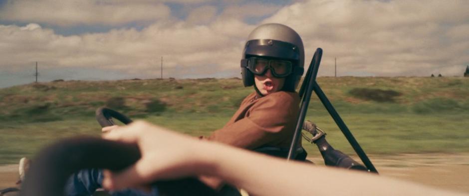 A boy racing next to Carol yells at her from his kart.