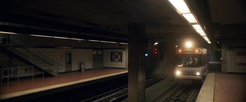 The train pulls into the station in front of a cloud of dust.