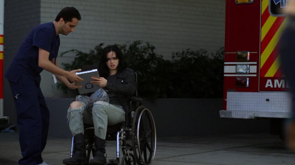 Jessica signs the release forms after being brought outside in the wheelchair.