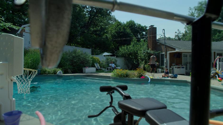 Sal Blaskowski sits on a chair in her backyard with her son and grandson while Erik is trapped at the bottom of her pool.