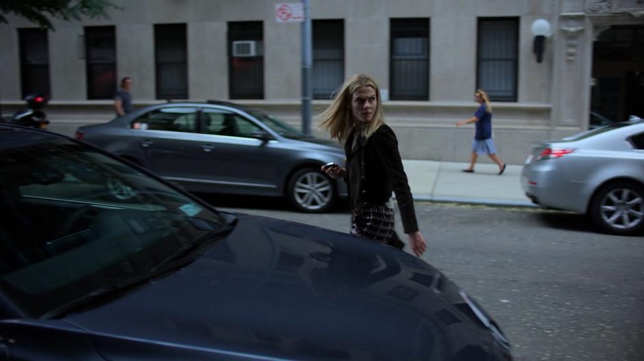 Trish looks back at Erik after passing him on the way to her car.