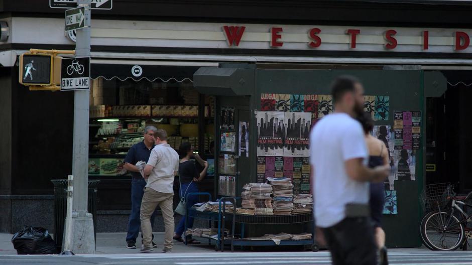 Gregory Sallinger buys a newspaper at the stand across the street from his building.