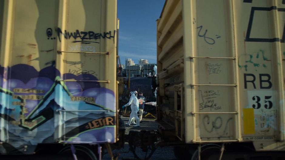 CSI employees dressed in hazmat suits collect body-parts from the tanker car.