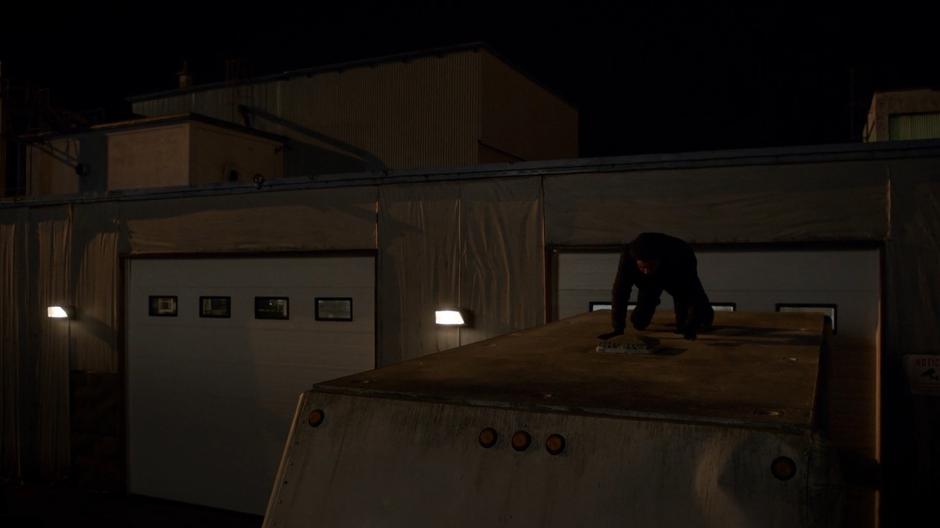 Ravi shuffles along the top of the truck to the small skylight.