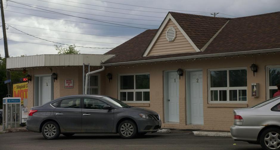 Emily's car sits in front of her motel room.