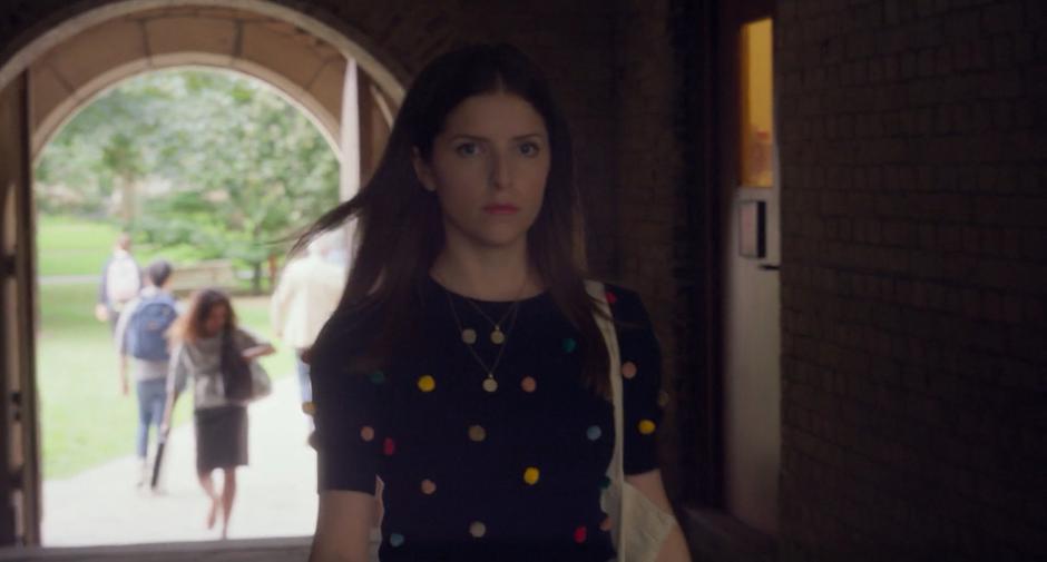 Stephanie walks through a tunnel towards hte courtyard.