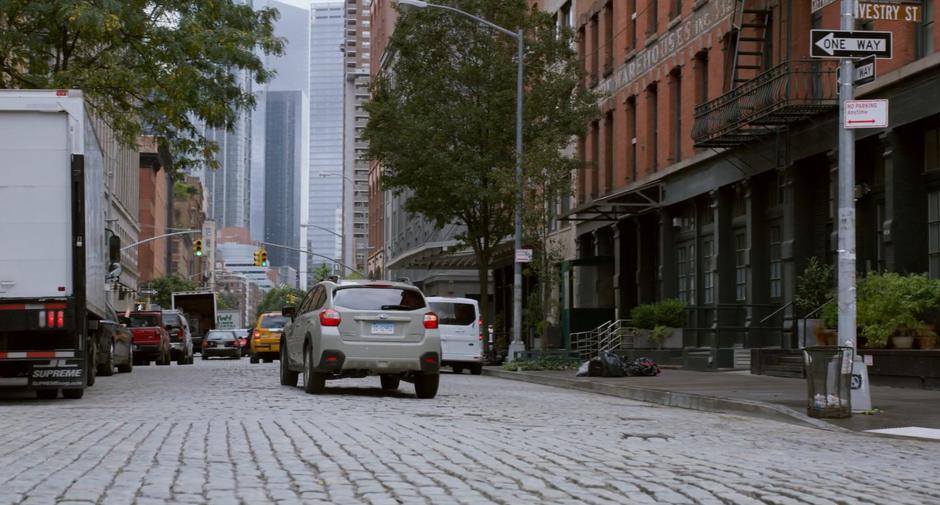 Stephanie turns the corner and continues driving through the city.