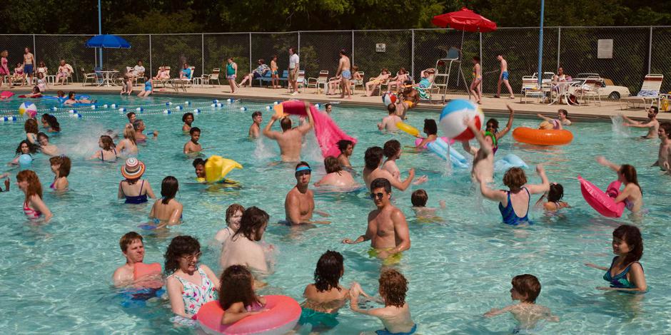 A bunch of people play around in the swimming pool.