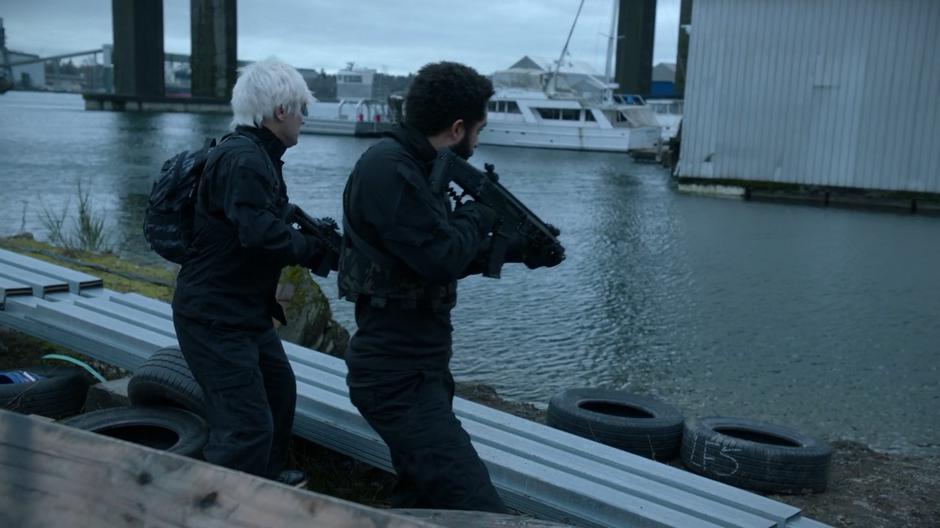 Two of Enzo Lambert's soldiers search the water for Major after he dove in to escape.