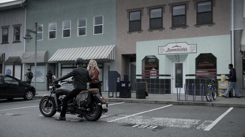 Candy grabs the helmet before getting onto the motorcycle with the man.