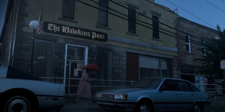 Exterior establishing shot of the newspaper office during the rainstorm.