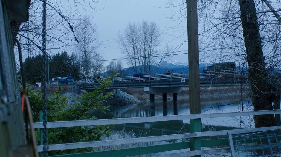 Protestors stand at one end of the bridge as the military checks cars passing through.