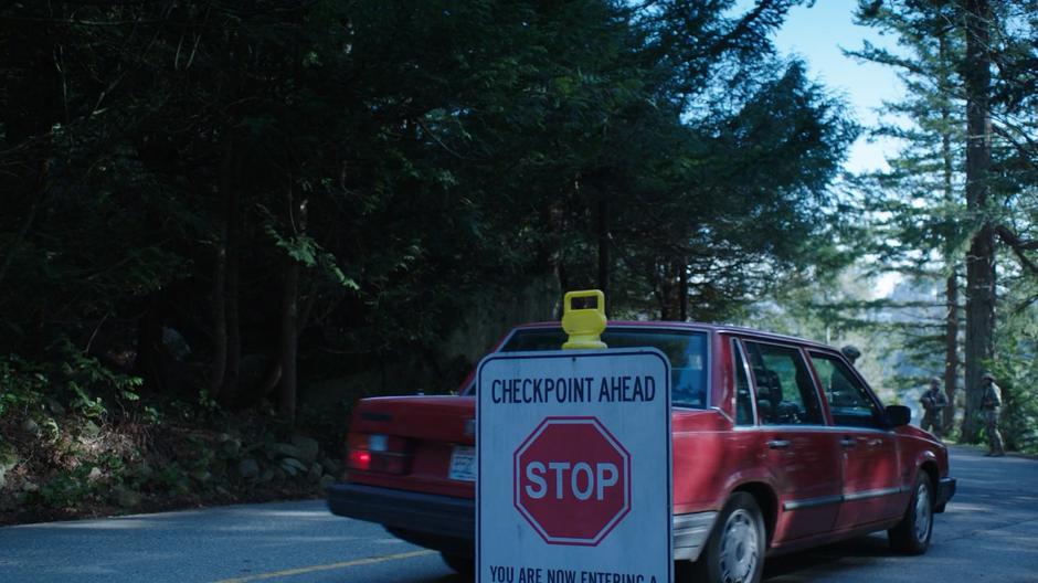 Helen pulls her car over to stop at the checkpoint.