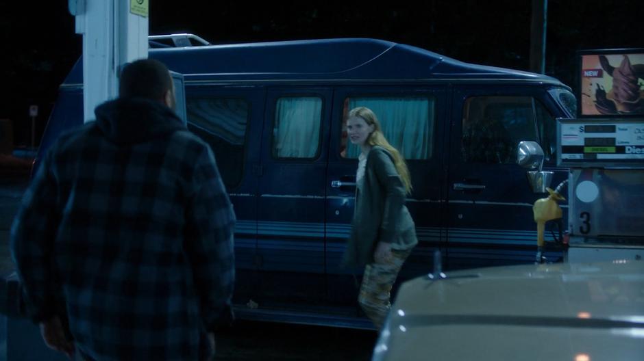 Xander rushes over to the van as Eliza gets his attention.