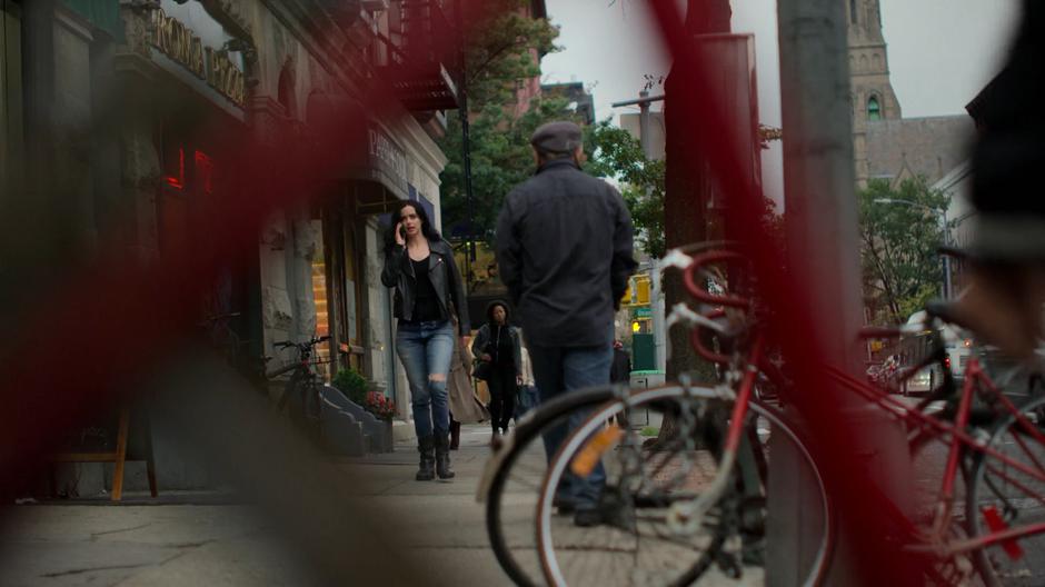 Jessica talks to Malcolm on the phone while walking down the street.