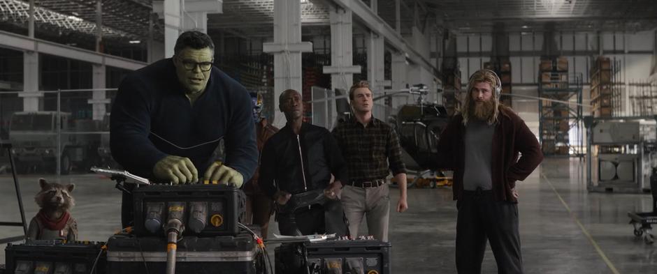 Rocket, Nebula, James, Steve, and Thor watch as Bruce works the controls to the time machine.