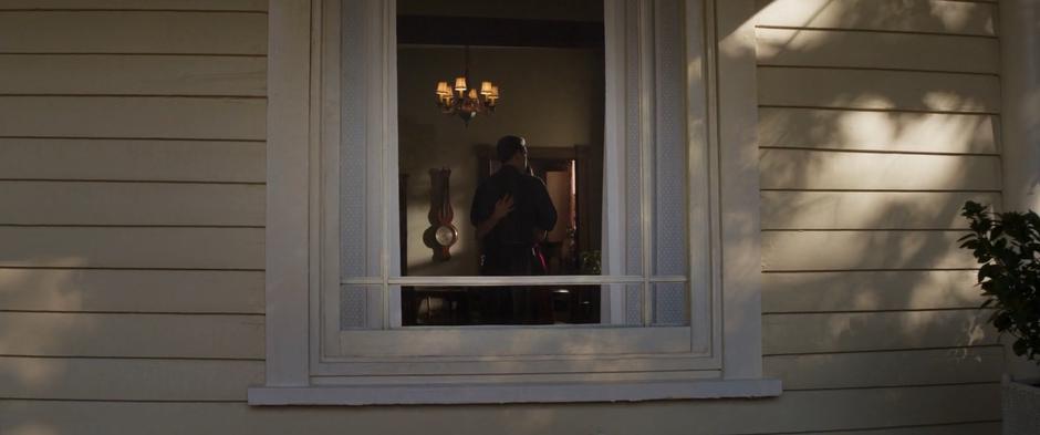 Steve and Peggy are visible through the window dancing.