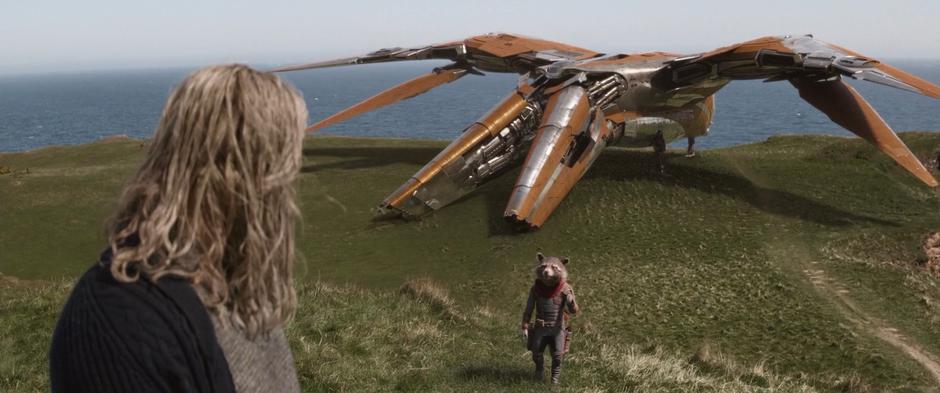 Rocket calls out for Thor as the Milano sits in the grass behind him.